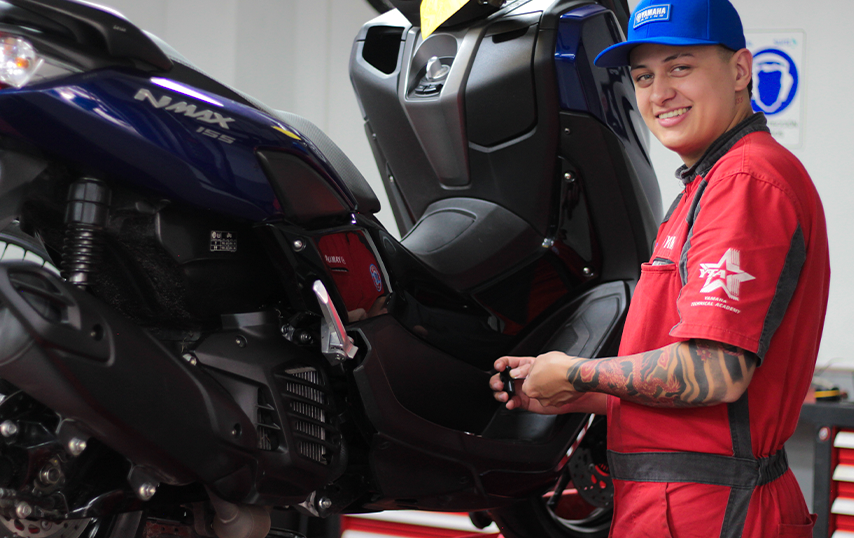 Técnico de motocicletas Yamaha realizando mantenimiento y ajustes de alta calidad